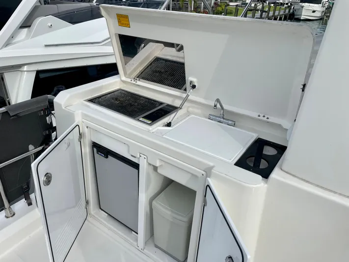  Yacht Photos Pics Outdoor kitchenette on 2026 Beneteau Swift Trawler 41 with grill, sink, and storage.