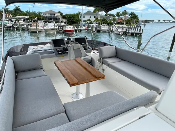  Yacht Photos Pics 2026 Beneteau Swift Trawler 41 with spacious outdoor seating and table, docked at a marina.