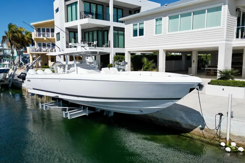  Yacht Photos Pics 2024 Intrepid 407 Nomad FE boat docked near modern waterfront homes.
