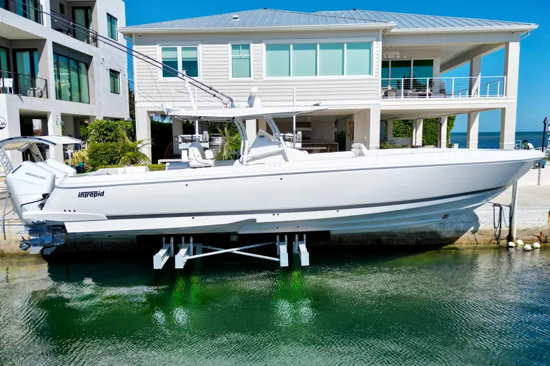  Yacht Photos Pics 2024 Intrepid 407 Nomad FE boat docked near modern waterfront home.