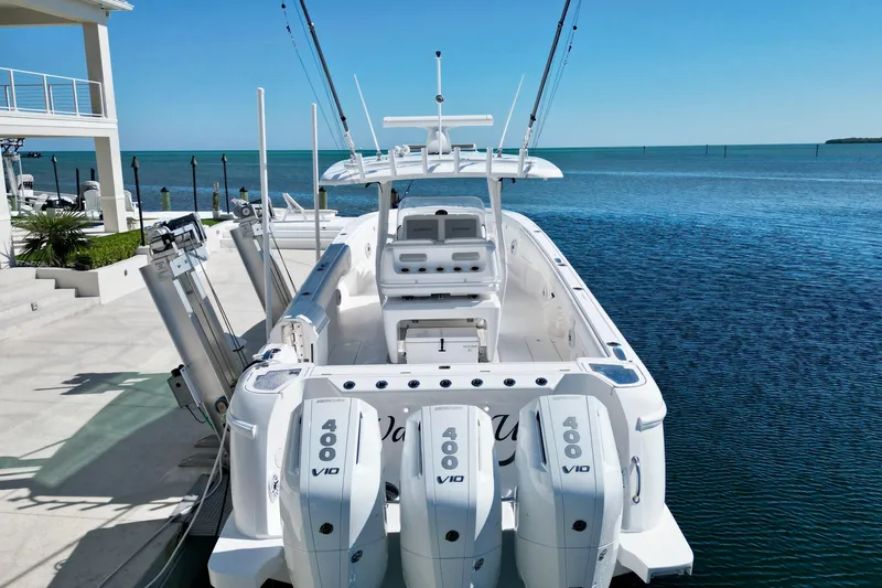  Yacht Photos Pics 2024 Intrepid 407 Nomad FE boat docked by the ocean, featuring triple Mercury 400 engines.