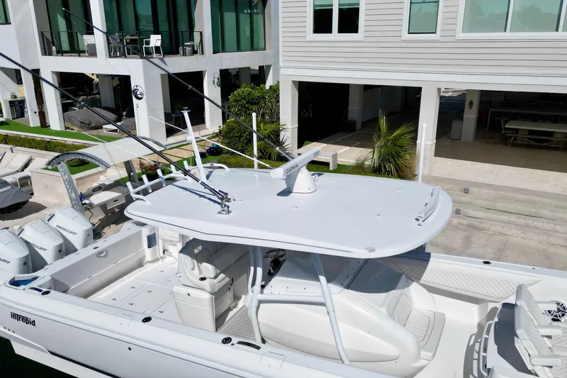  Yacht Photos Pics 2024 Intrepid 407 Nomad FE boat docked near modern waterfront home.