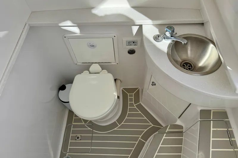  Yacht Photos Pics 2024 Intrepid 407 Nomad FE boat bathroom with toilet and stainless steel sink.