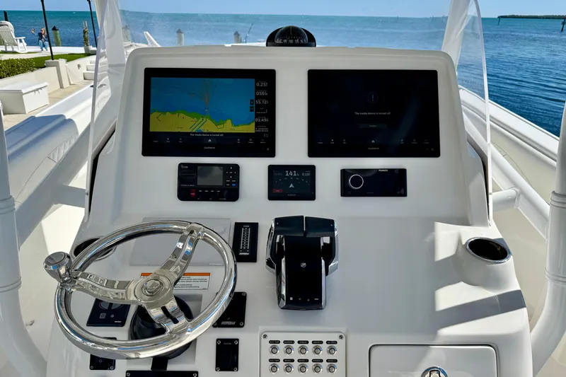  Yacht Photos Pics 2024 Intrepid 407 Nomad FE helm with navigation screens and steering wheel, overlooking the ocean.