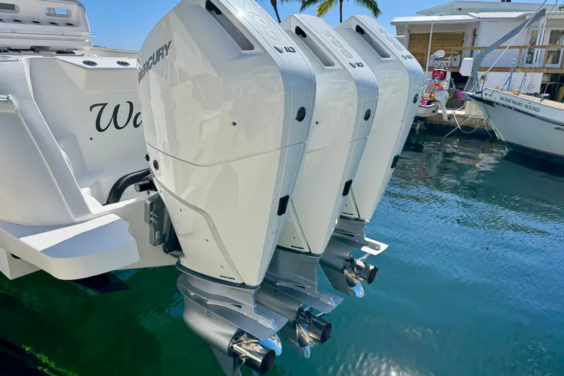  Yacht Photos Pics 2024 Intrepid 407 Nomad FE with triple Mercury outboard engines docked by the water.