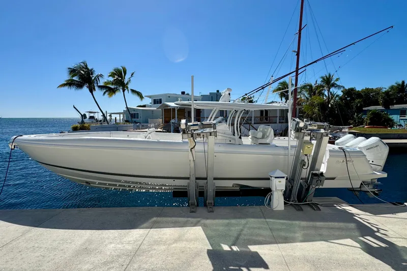  Yacht Photos Pics 2024 Intrepid 407 Nomad FE boat docked by waterfront with palm trees.