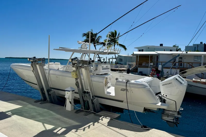  Yacht Photos Pics 2024 Intrepid 407 Nomad FE boat docked with dual Mercury engines, under clear blue sky.
