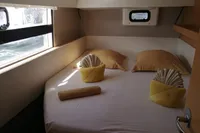 Cozy cabin interior of 2018 Nautitech 40 Open catamaran with neatly arranged bed and porthole view.