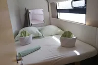 Cozy cabin interior of 2018 Nautitech 40 Open with neatly arranged bed and window view.