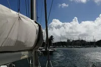 2018 Nautitech 40 Open catamaran sailing in sunny marina with blue sky and clouds.