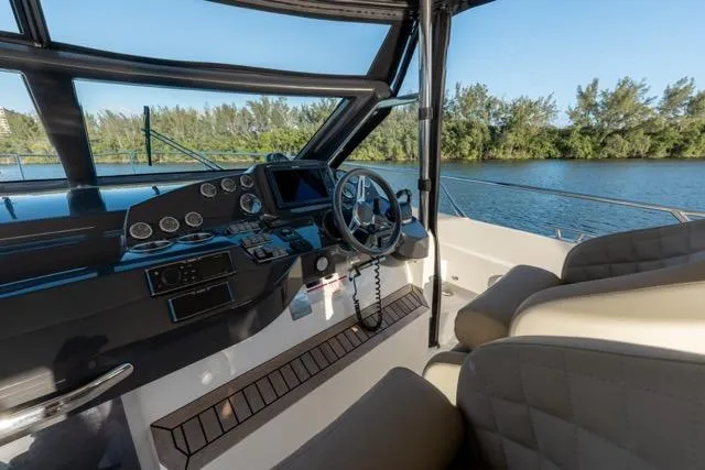  Yacht Photos Pics 2019 Absolute 40 SLT yacht cockpit with steering wheel, dashboard, and river view.