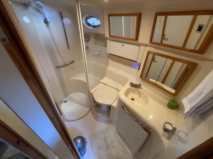 Salad Yacht Photos Pics Bathroom interior of 1997 Sea Ray 450 Sundancer yacht, featuring shower, sink, and mirrors.