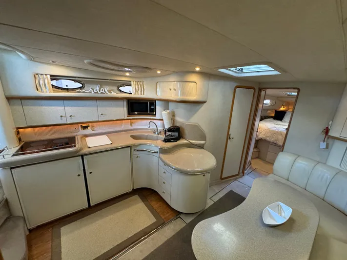 Salad Yacht Photos Pics Interior of a 1997 Sea Ray 450 Sundancer yacht, featuring a modern kitchen and cozy seating area.