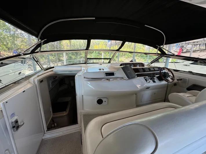 Salad Yacht Photos Pics 1997 Sea Ray 450 Sundancer cockpit with steering wheel and seating under black canopy.