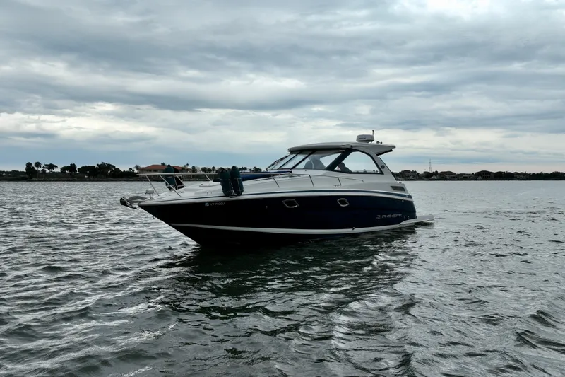 Motivated Yacht Photos Pics 2017 Regal 35 Sport Coupe boat on calm water under cloudy sky.