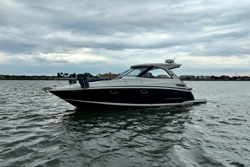 Motivated Yacht Photos Pics 2017 Regal 35 Sport Coupe on calm waters under cloudy sky.