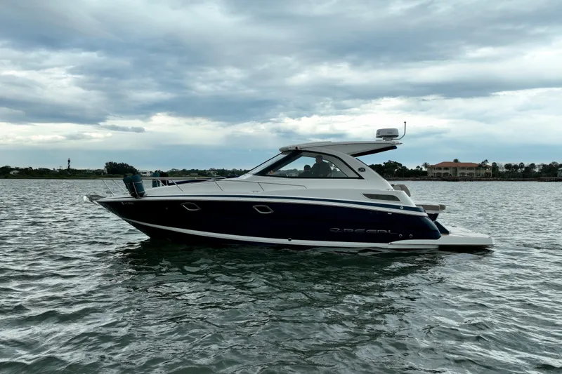Motivated Yacht Photos Pics 2017 Regal 35 Sport Coupe boat on calm water under cloudy sky.