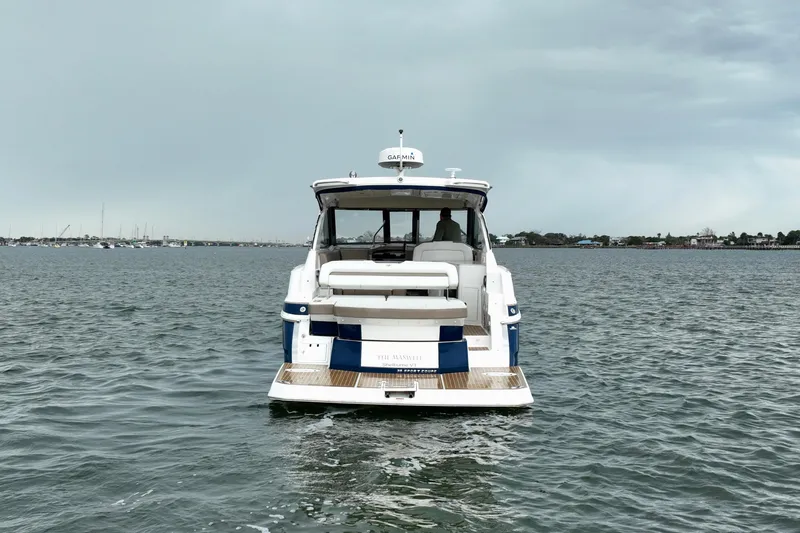 Motivated Yacht Photos Pics 2017 Regal 35 Sport Coupe on calm water, rear view with overcast sky.