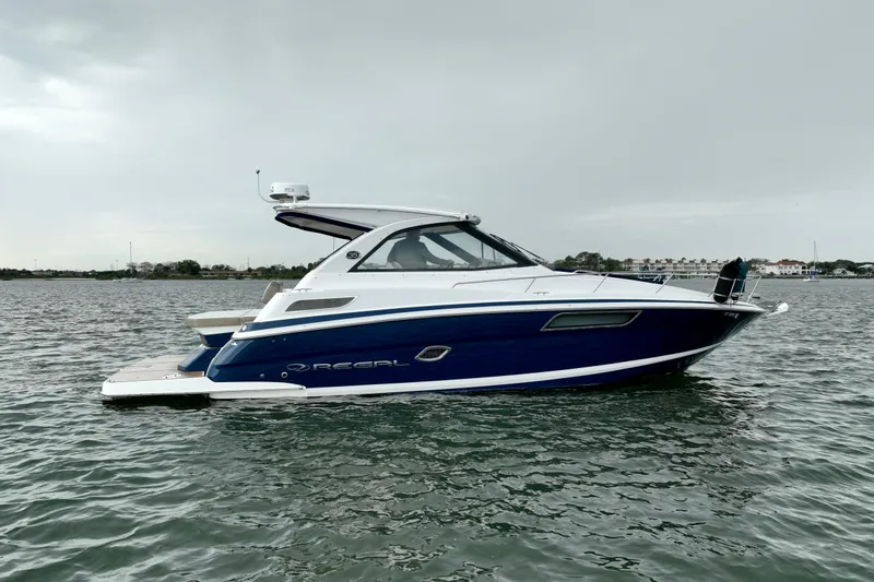 Motivated Yacht Photos Pics 2017 Regal 35 Sport Coupe boat on calm water, side view.