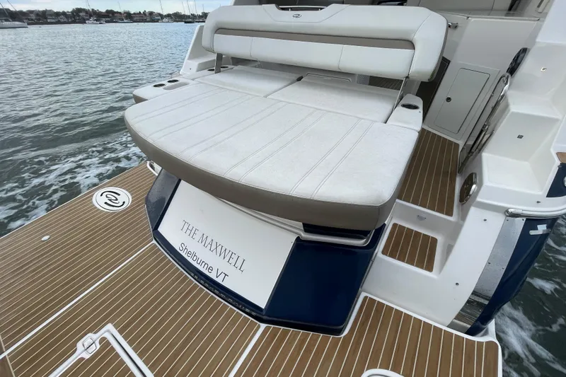 Motivated Yacht Photos Pics 2017 Regal 35 Sport Coupe boat with cushioned seating and wooden deck.
