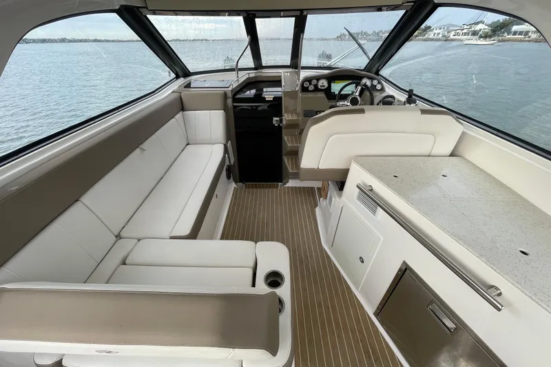 Motivated Yacht Photos Pics Interior of 2017 Regal 35 Sport Coupe, featuring elegant seating and helm, overlooking water.