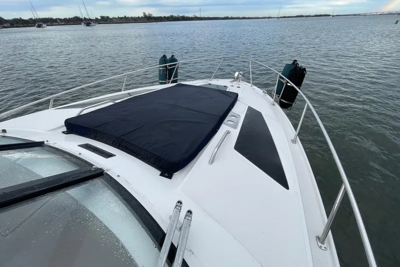 Motivated Yacht Photos Pics 2017 Regal 35 Sport Coupe yacht bow on calm water, featuring sleek design and sun pad.