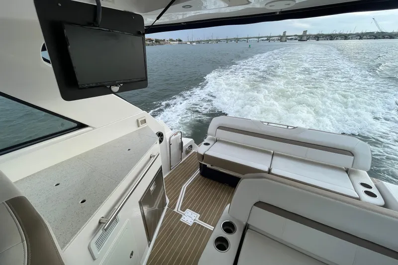 Motivated Yacht Photos Pics 2017 Regal 35 Sport Coupe interior with seating, TV, and ocean view.