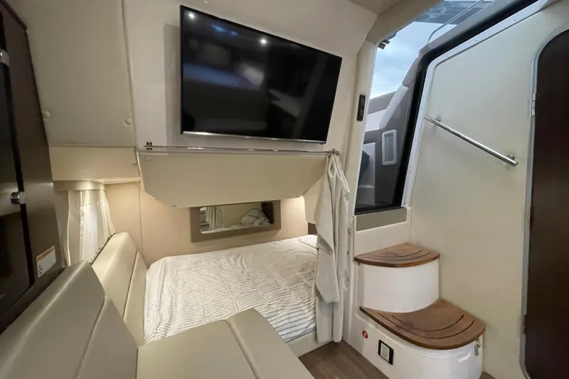 Motivated Yacht Photos Pics Interior of 2017 Regal 35 Sport Coupe with bed, TV, and stairs.