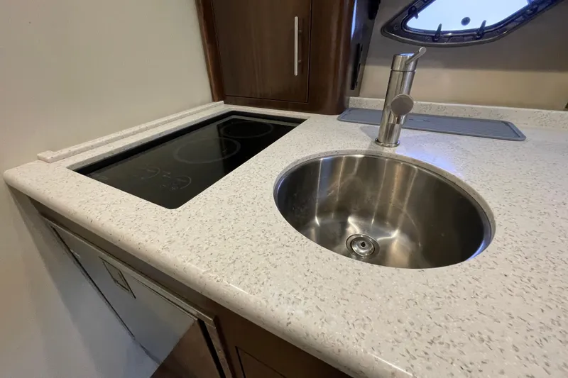 Motivated Yacht Photos Pics 2017 Regal 35 Sport Coupe kitchen with sink and induction cooktop.