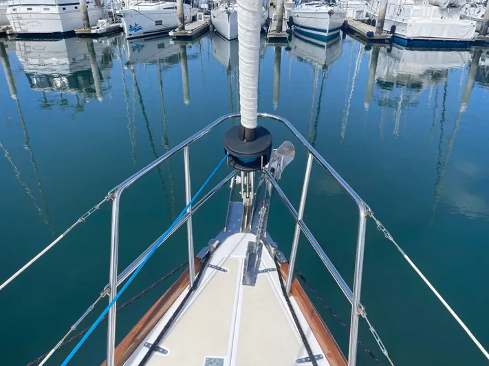 Full Sail Yacht Photos Pics Bow of 2003 Tartan 4600 sailboat docked in marina with calm water reflections.