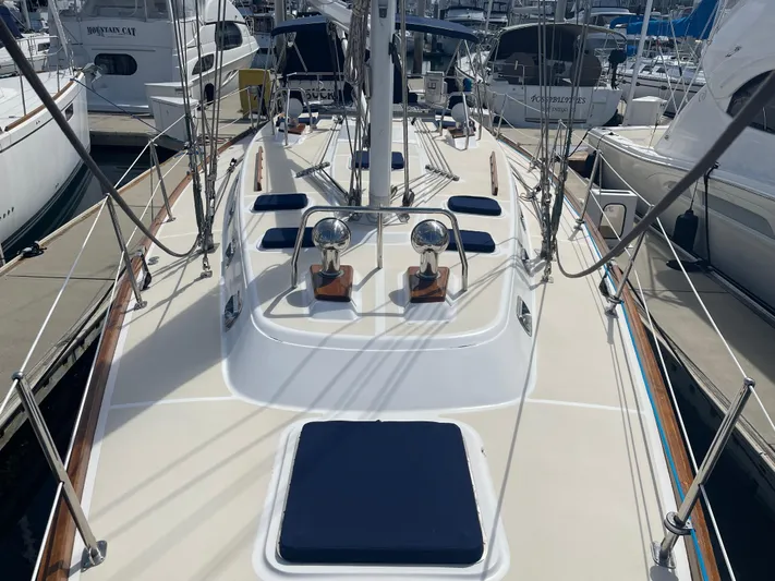 Full Sail Yacht Photos Pics 2003 Tartan 4600 sailboat deck with blue cushions, docked at a marina.