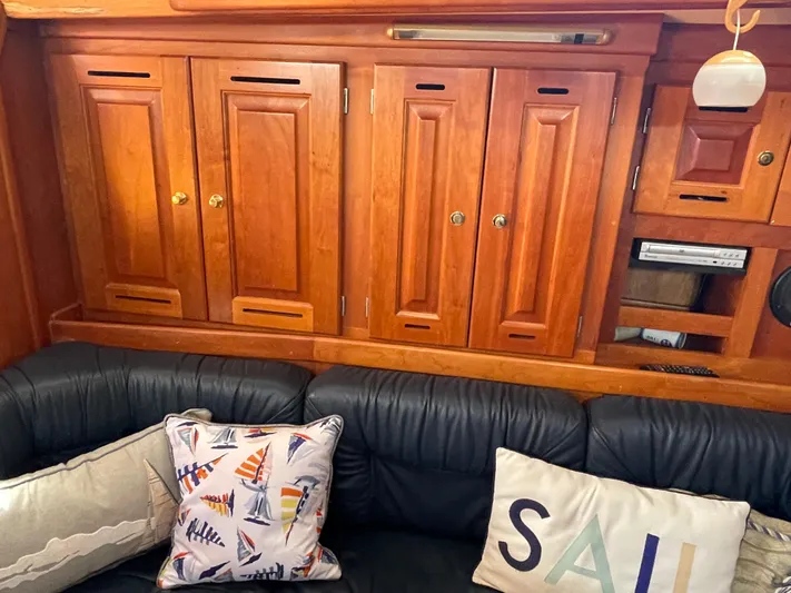 Full Sail Yacht Photos Pics Interior of 2003 Tartan 4600 yacht with wooden cabinets and nautical-themed pillows.