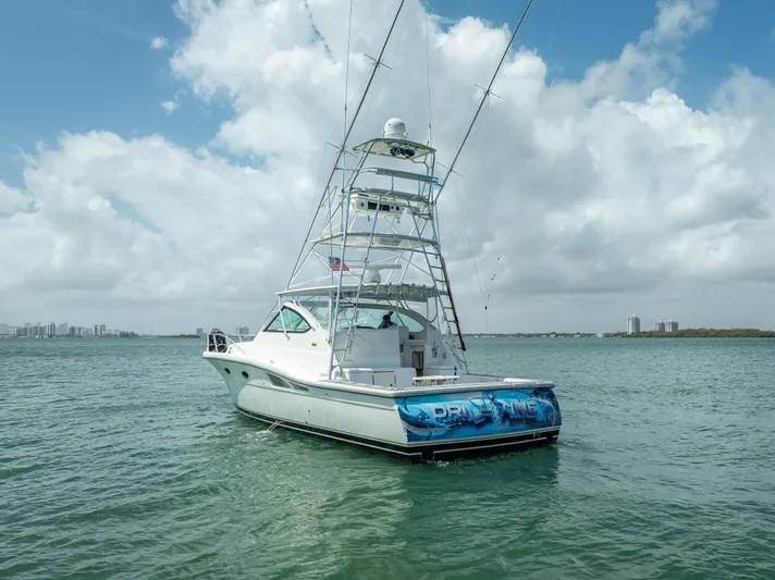 Drill Time Yacht Photos Pics 2006 Tiara Yachts 4200 Open on water, clear sky, fishing tower, city skyline in background.