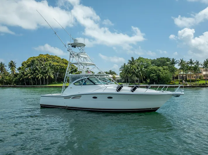Drill Time Yacht Photos Pics 2006 Tiara Yachts 4200 Open on tranquil water with lush tropical backdrop.