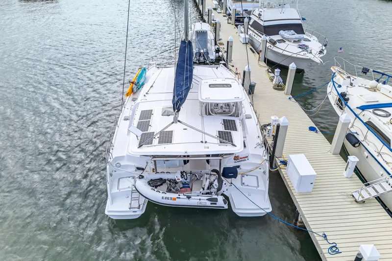  Yacht Photos Pics 2016 Leopard 44 Owners Version catamaran docked at marina with solar panels and dinghy.