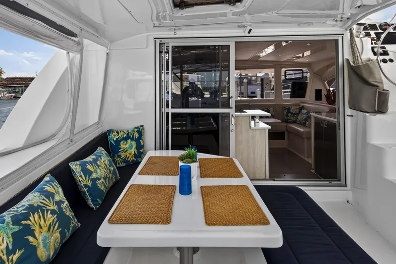  Yacht Photos Pics 2016 Leopard 44 Owners Version catamaran interior with dining area, cushions, and sliding glass doors.