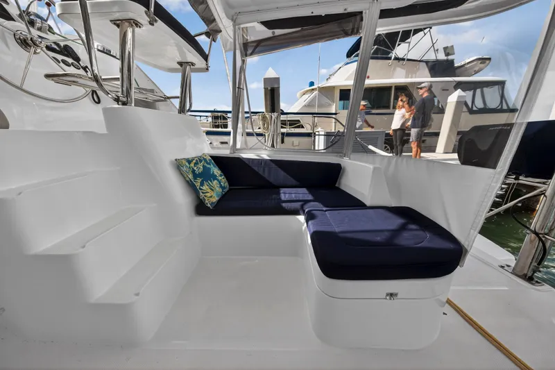 Yacht Photos Pics 2016 Leopard 44 Owners Version yacht interior with blue cushioned seating and decorative pillow.