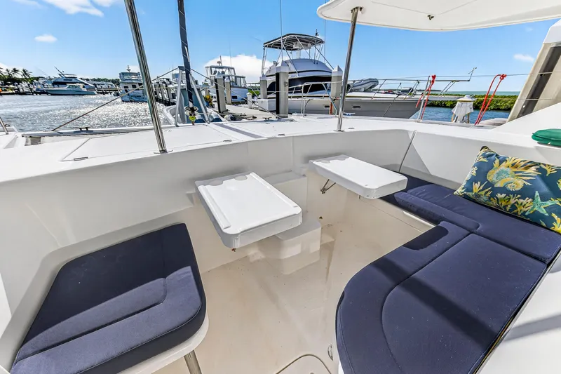  Yacht Photos Pics 2016 Leopard 44 Owners Version yacht cockpit with seating and tables, docked at marina.