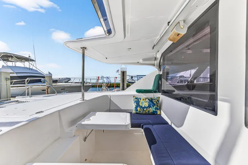  Yacht Photos Pics 2016 Leopard 44 Owners Version yacht interior with seating and table, docked at marina.