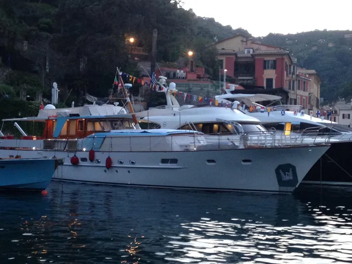  Yacht Photos Pics Classic 1965 Feadship CARAVELLE 23 yacht docked in a scenic harbor.