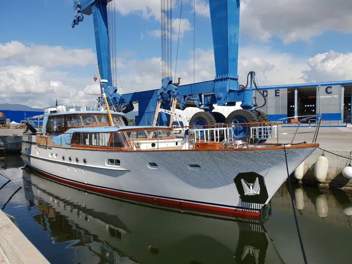  Yacht Photos Pics Classic 1965 Feadship CARAVELLE 23 yacht docked at a marina under blue skies.