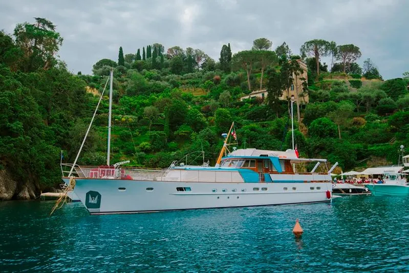  Yacht Photos Pics Feadship CARAVELLE 23 yacht, 1965 model, anchored near lush green hillside.