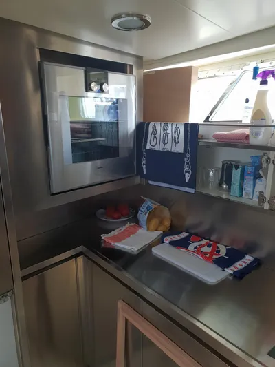  Yacht Photos Pics Compact kitchen area on 1965 Feadship CARAVELLE 23 yacht with modern appliances and storage.