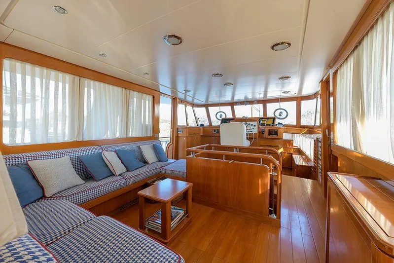  Yacht Photos Pics Luxurious interior of 1965 Feadship CARAVELLE 23 yacht with wood paneling and plush seating.