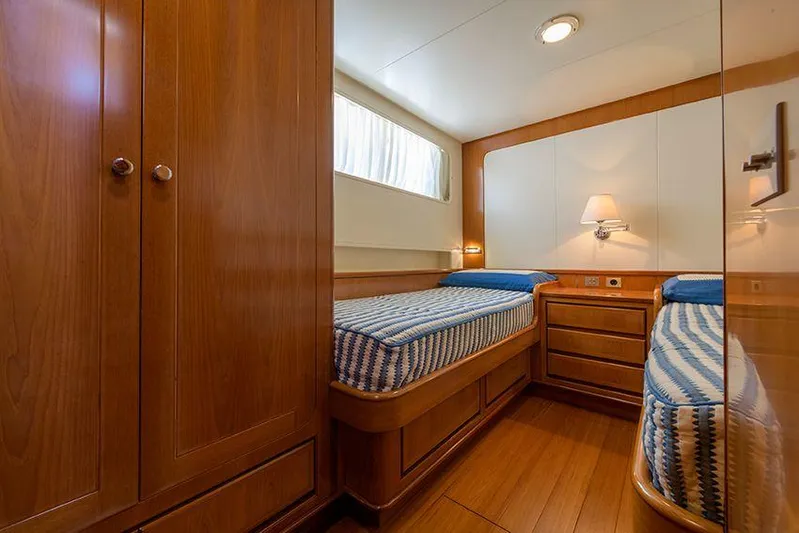  Yacht Photos Pics Luxurious cabin interior of 1965 Feadship CARAVELLE 23 yacht with twin beds and wooden furnishings.