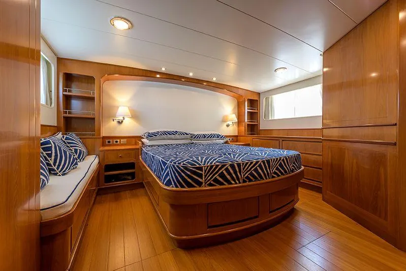  Yacht Photos Pics Luxurious cabin interior of 1965 Feadship CARAVELLE 23 yacht with wood finish and elegant bedding.