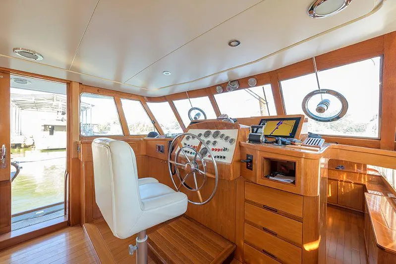  Yacht Photos Pics Interior of 1965 Feadship CARAVELLE 23 yacht, featuring classic wooden helm and modern navigation equipment.