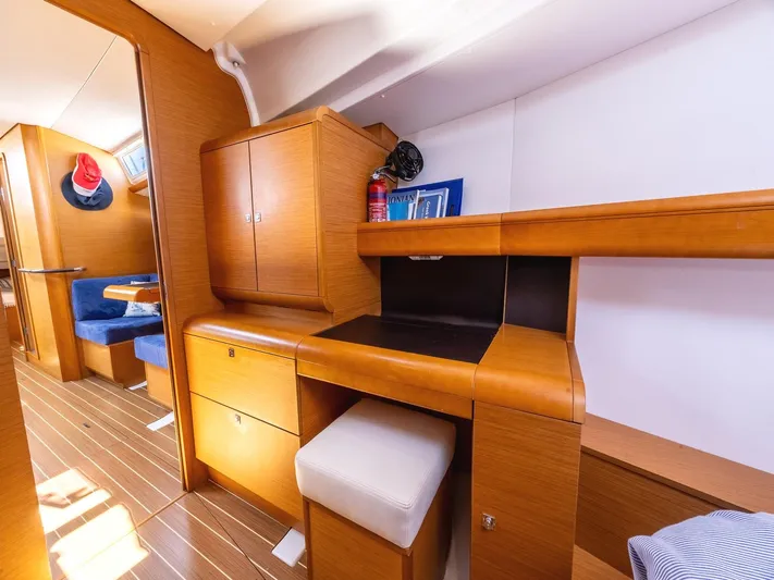  Yacht Photos Pics Interior of 2013 Jeanneau Sun Odyssey 439, featuring wooden cabinetry and seating area.