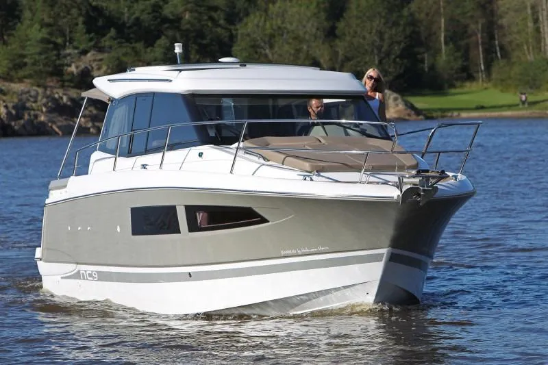  Yacht Photos Pics Manufacturer Provided Image: 2017 Jeanneau NC 9 boat cruising on a lake with lush green background.