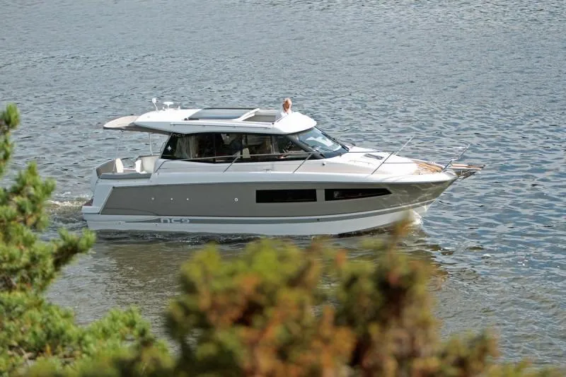  Yacht Photos Pics Manufacturer Provided Image: 2017 Jeanneau NC 9 boat cruising on a calm waterway.